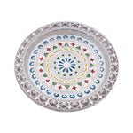 Silver pooja thali showing intricate design.