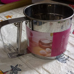 Easy-to-use manual flour sifter with a shaker mechanism, ideal for precise and lump-free baking.